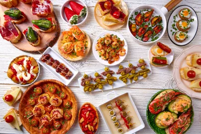 Tapas mix and pinchos food on a white wood board