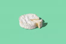 Camembert Cheese on green background